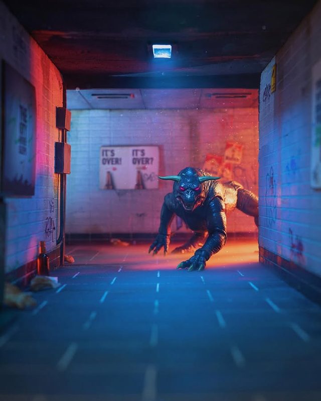 A horned creature crawling through a subway corridor lit in red and blue